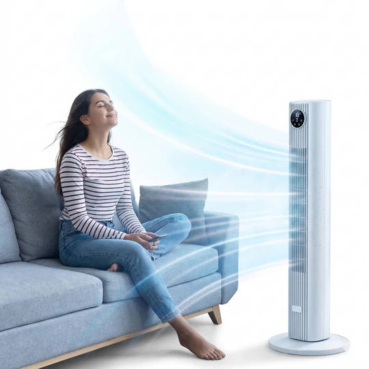 Woman sitting on a couch with a tower fan blowing air towards her