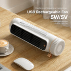 A white USB rechargeable tower fan with a black front grille and a small copper accent, shown on a wooden desk next to a coffee cup and mouse. Text on the image reads 'USB Rechargeable Fan 5W/5V'.